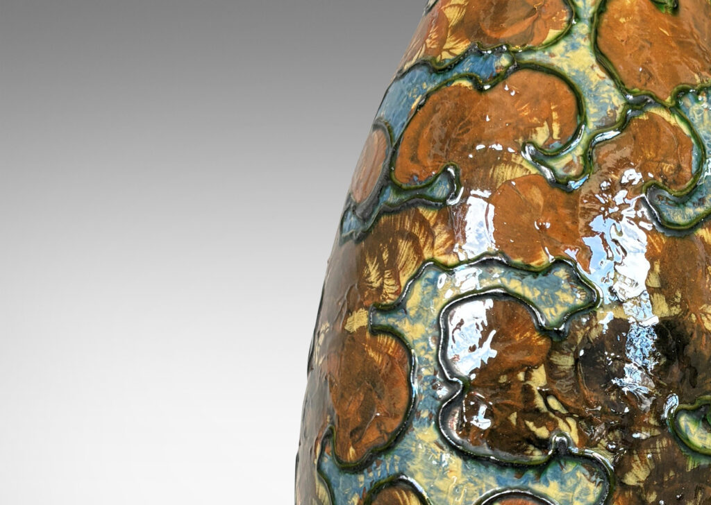 Gallery BAC undulating form with piped relief cloud-like pattern, with fields glazed in burnt orange and light blue