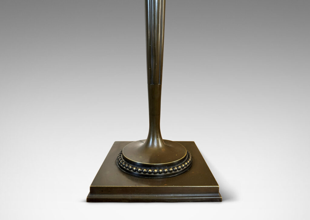 Gallery BAC torch form with tapered and fluted stand, mitered square base, and rings of beading; patinated bronze