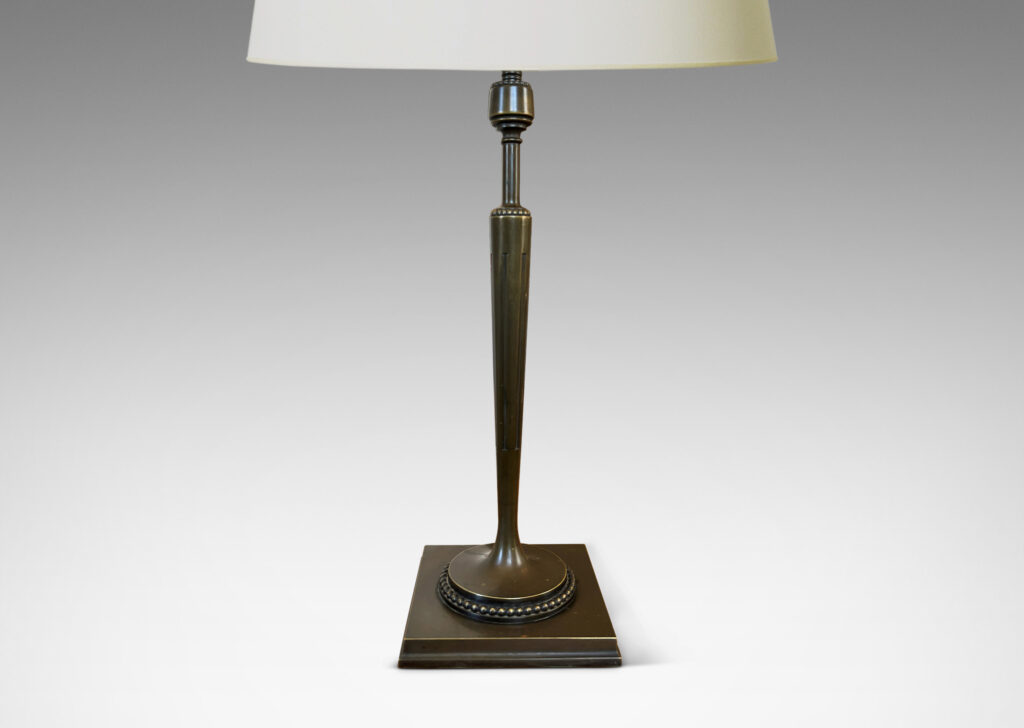 Gallery BAC torch form with tapered and fluted stand, mitered square base, and rings of beading; patinated bronze