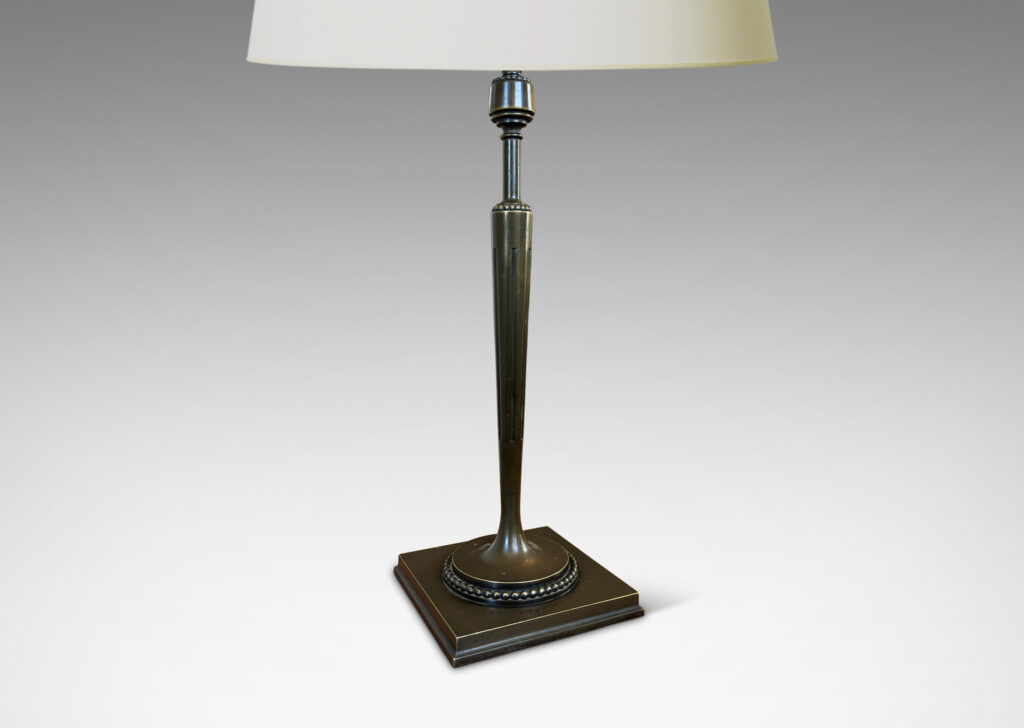 Gallery BAC torch form with tapered and fluted stand, mitered square base, and rings of beading; patinated bronze