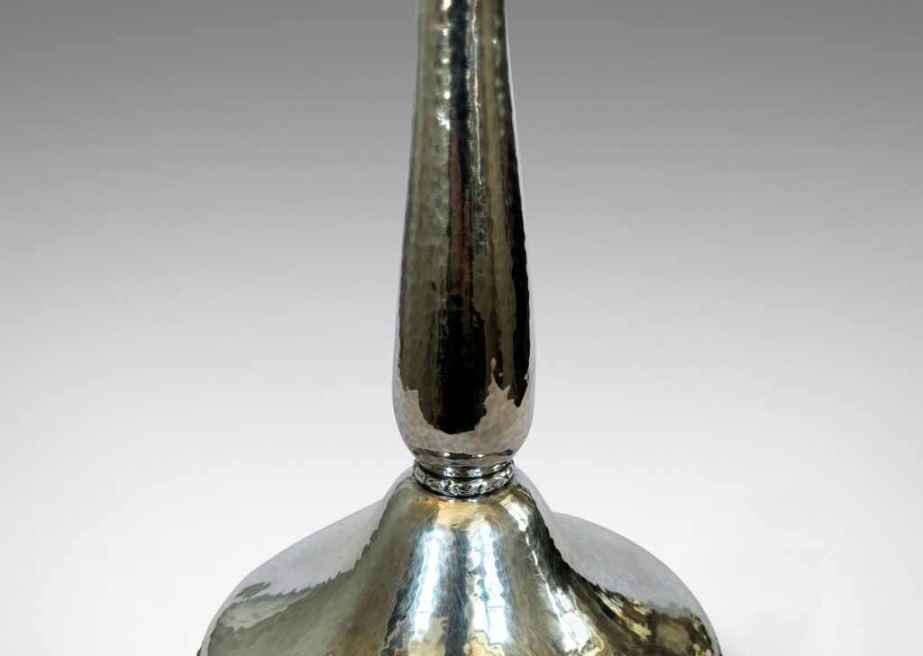 Gallery BAC sinuous baluster form on a pillowy round base, with a shimmering hammered finish and embossed foliate pattern bands, silver plate brass