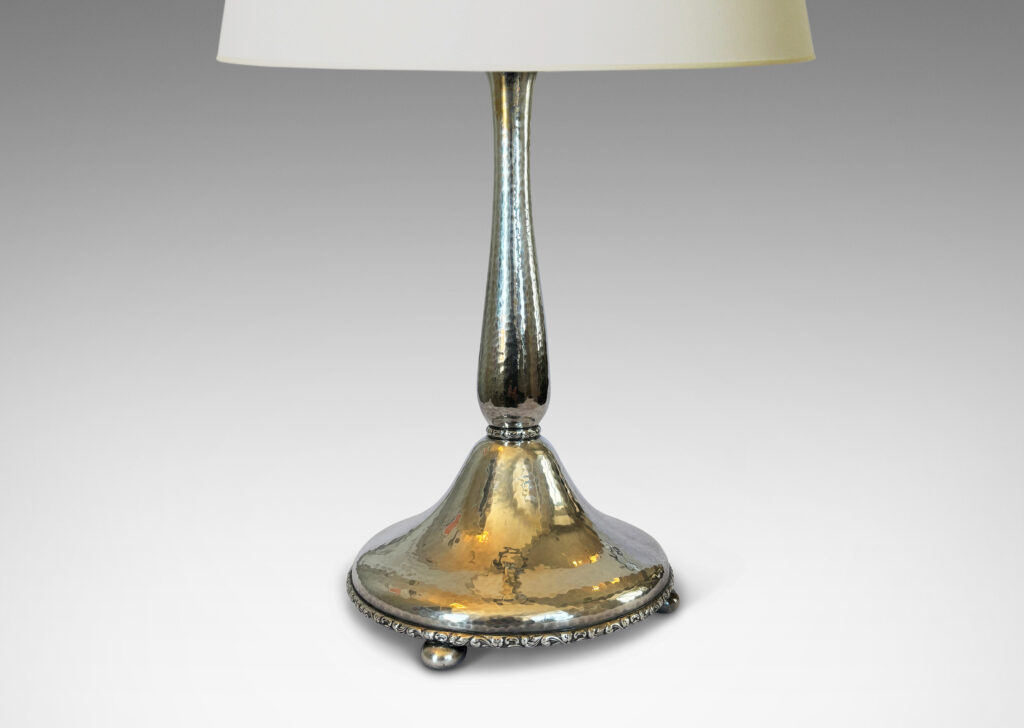 Gallery BAC sinuous baluster form on a pillowy round base, with a shimmering hammered finish and embossed foliate pattern bands, silver plate brass