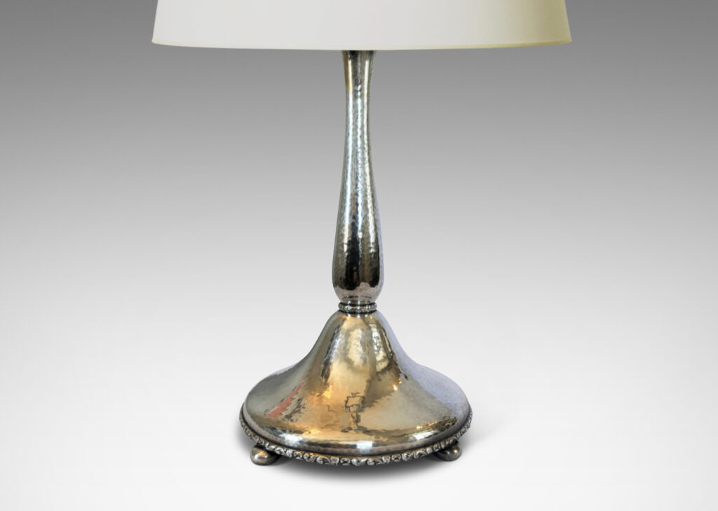 Gallery BAC sinuous baluster form on a pillowy round base, with a shimmering hammered finish and embossed foliate pattern bands, silver plate brass