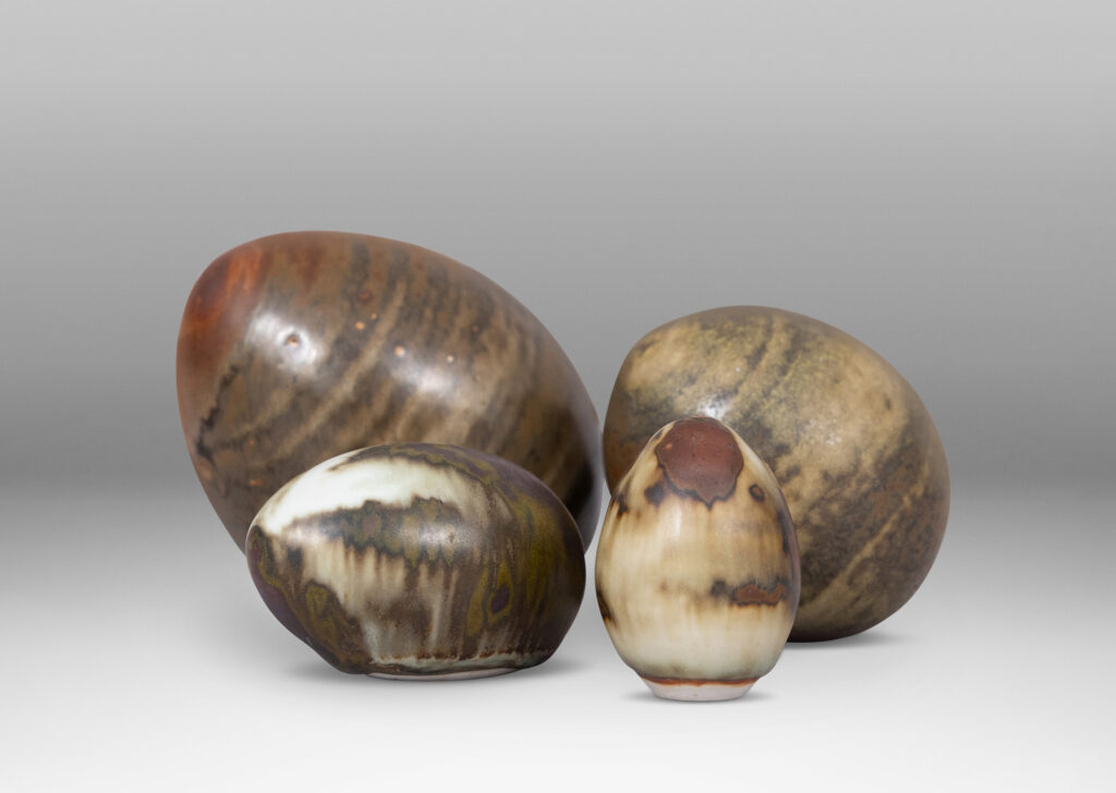 Gallery BAC egg forms in different sizes and sitting at different angles, each in a pale taupe and brown