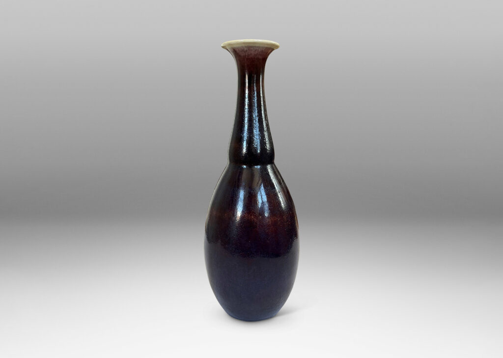 Gallery BAC ovoid body with articulated neck and flared mouth, glazed in a plummy oxblood tone with pale gray accents