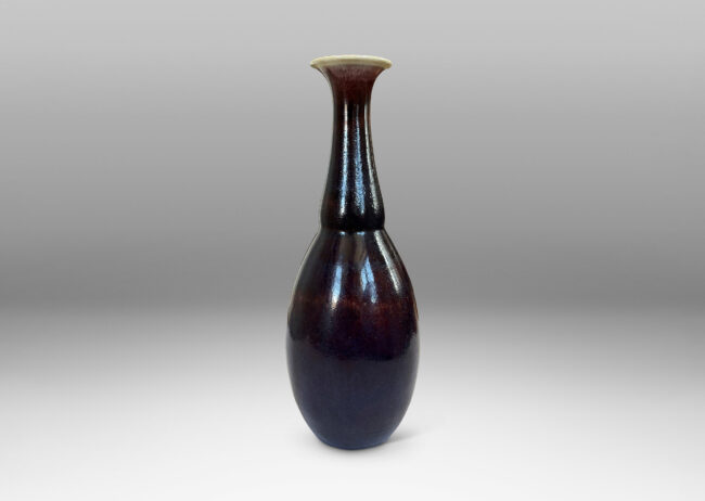 Gallery BAC ovoid body with articulated neck and flared mouth, glazed in a plummy oxblood tone with pale gray accents