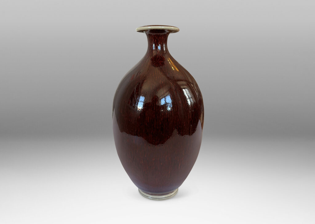 Gallery BAC ovoid form with sprouting neck and flange mouth, glazed in a glossy oxblood with pale gray accents