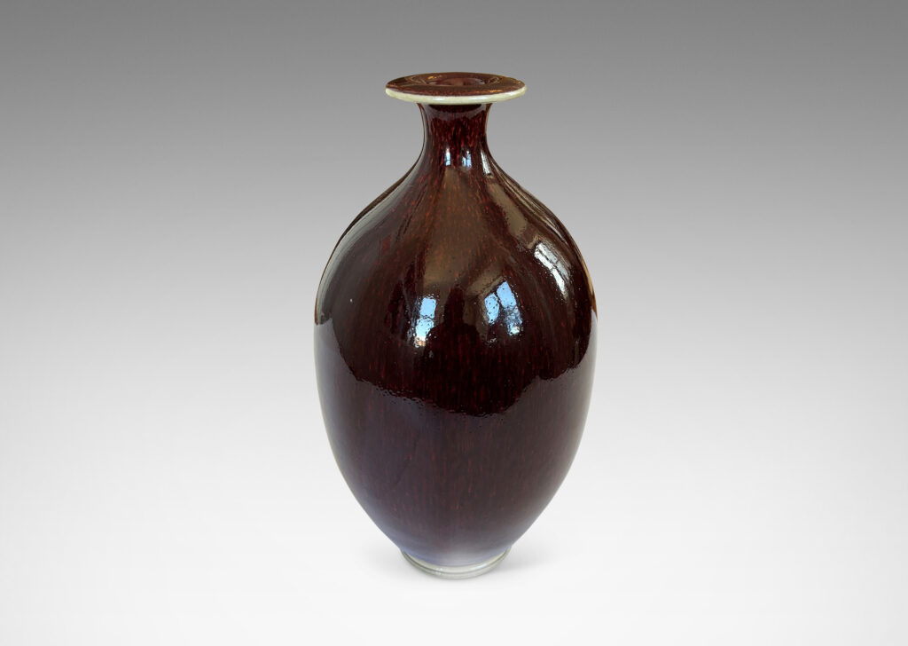 Gallery BAC ovoid form with sprouting neck and flange mouth, glazed in a glossy oxblood with pale gray accents
