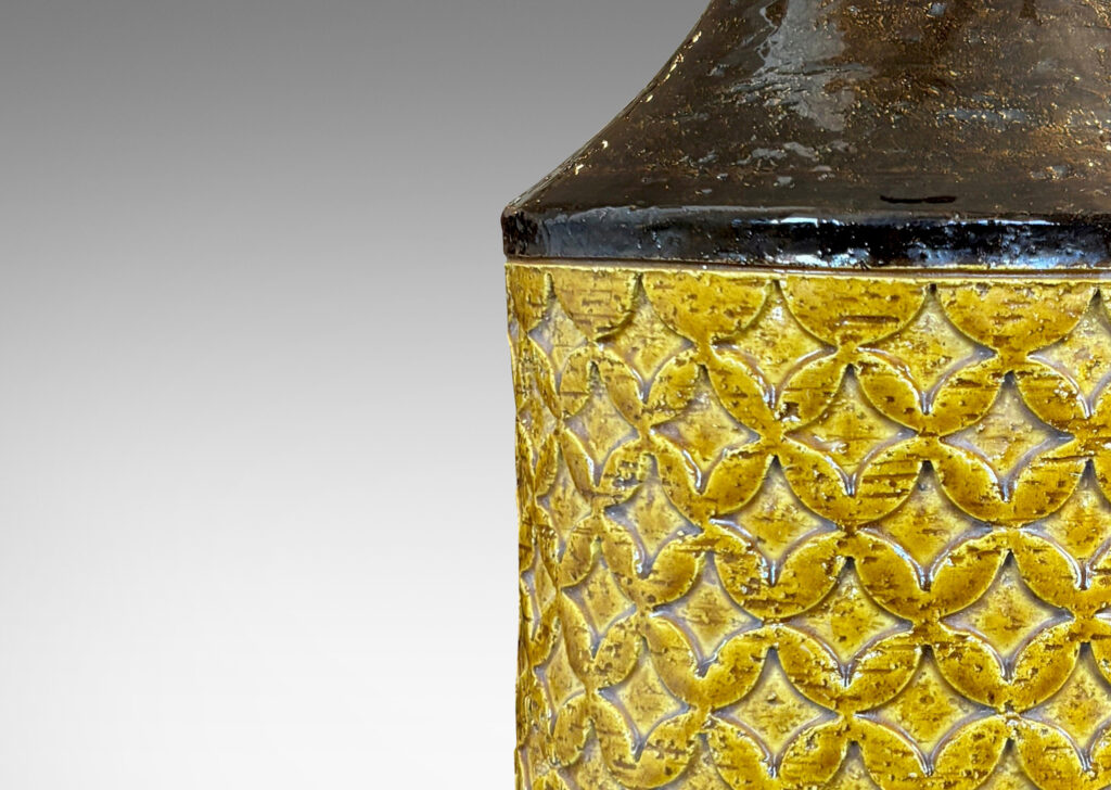 Gallery BAC cylindrical forms with coved necks and geometric reliefs, glazed in a golden yellow and dark brown