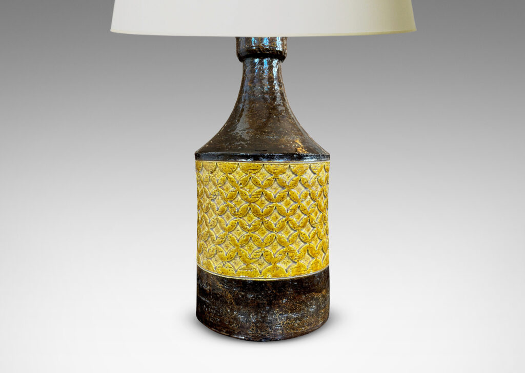 Gallery BAC cylindrical forms with coved necks and geometric reliefs, glazed in a golden yellow and dark brown