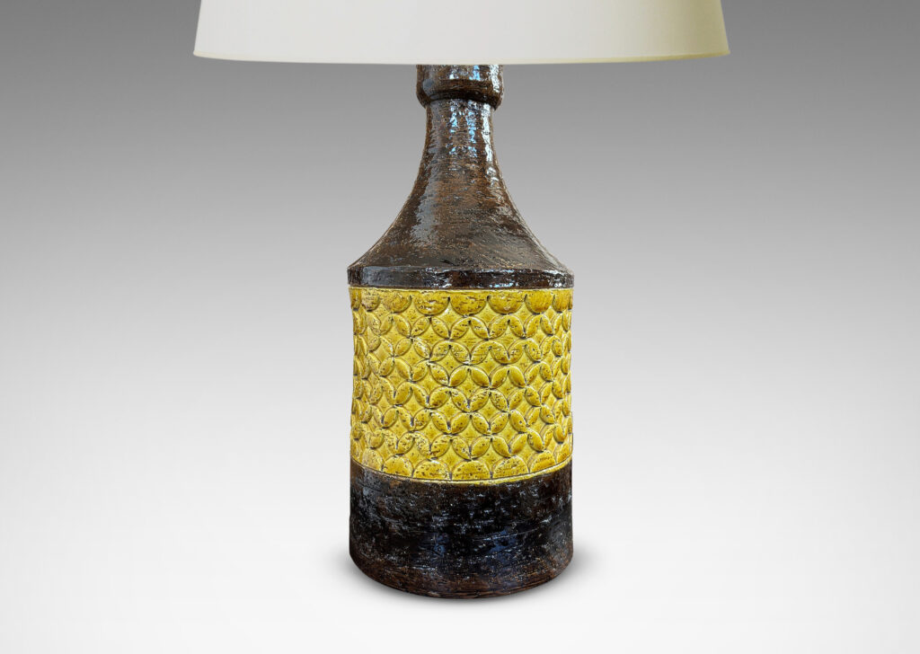 Gallery BAC cylindrical forms with coved necks and geometric reliefs, glazed in a golden yellow and dark brown
