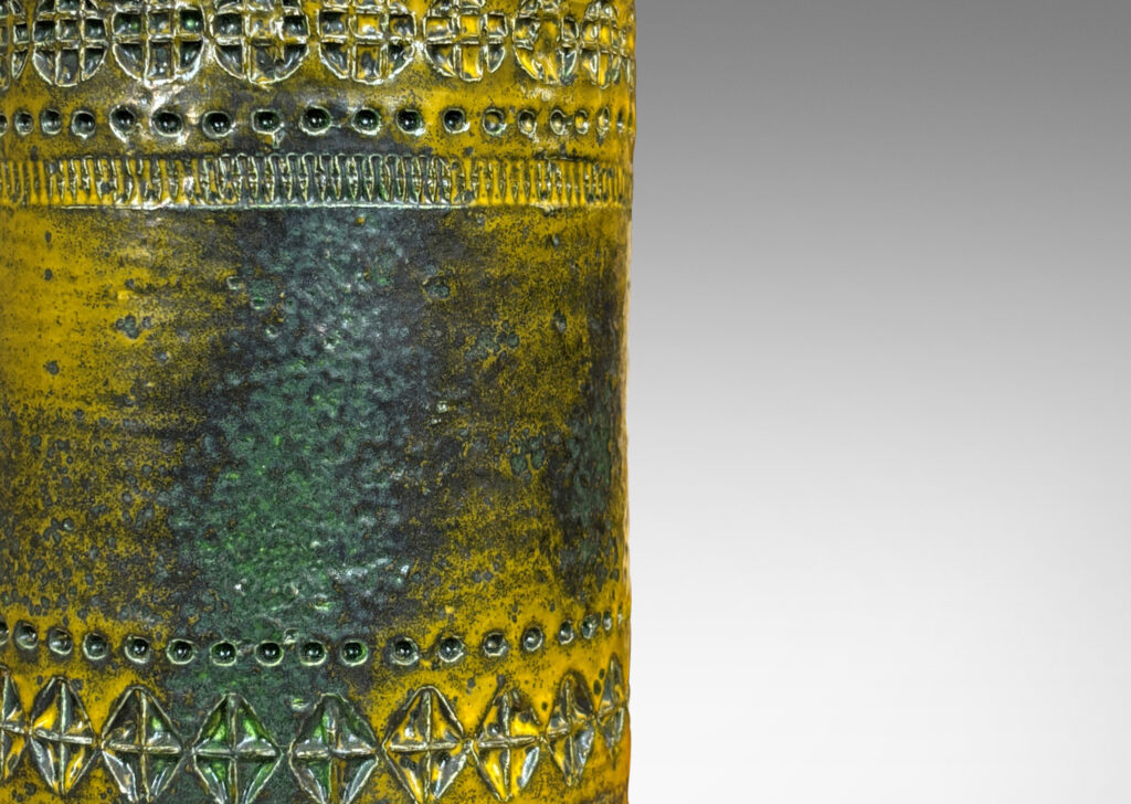 Gallery BAC medium height cylindrical form encircled in bands of impressed geometric ornaments, glazed in mustard yellow with green-gray