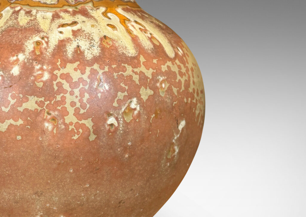 Gallery BAC apered globe form in a marvelous light tan over terra cotta glazing, with bronze patinated lid ornamented with ruffle, coil and finial