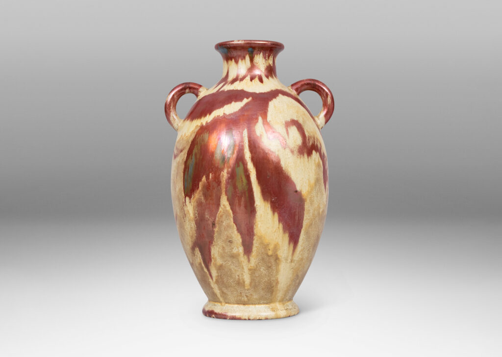 Gallery BAC large tapered ovoid form with pair of ear handles, glazed in sandy gold tones with abstract leaf design in red luster