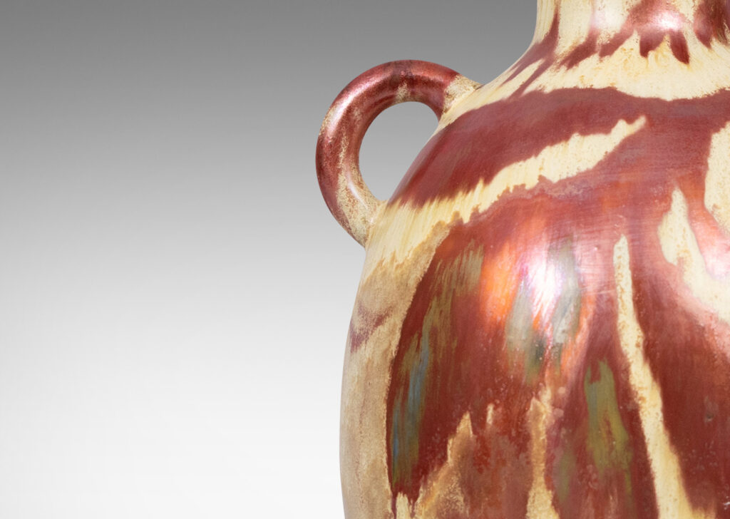 Gallery BAC large tapered ovoid form with pair of ear handles, glazed in sandy gold tones with abstract leaf design in red luster