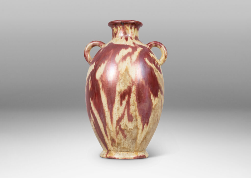 Gallery BAC large tapered ovoid form with pair of ear handles, glazed in sandy gold tones with abstract leaf design in red luster