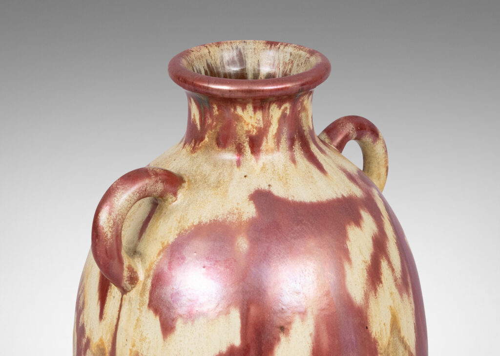 Gallery BAC large tapered ovoid form with pair of ear handles, glazed in sandy gold tones with abstract leaf design in red luster