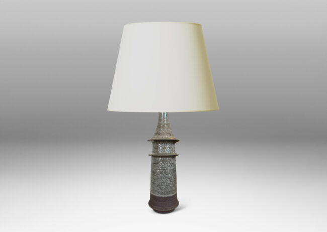 Gallery BAC swelling conical form with flared rings and ornamented with carved zig-zags and impressed rosettes, glazed in a pale warm gray and matte brown