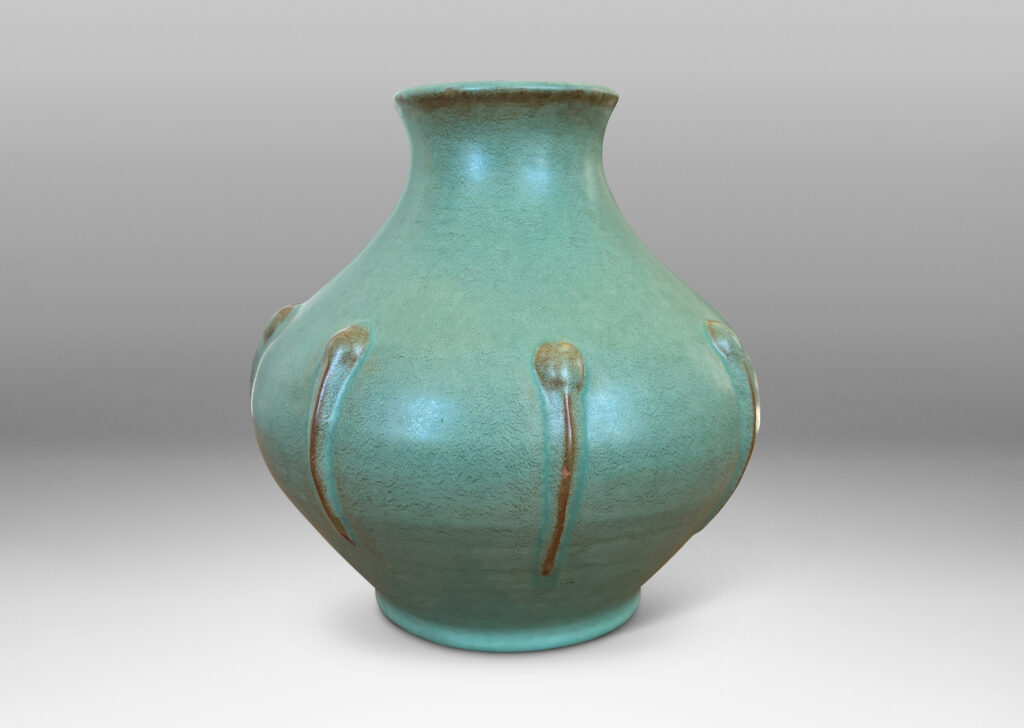 Gallery BAC bulbous form with outstretched mouth and relief organic motifs, in a celadon green glaze with brown accents