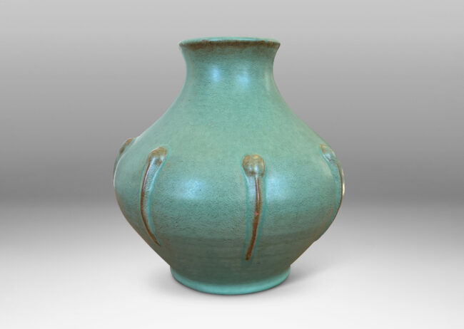 Gallery BAC bulbous form with outstretched mouth and relief organic motifs, in a celadon green glaze with brown accents