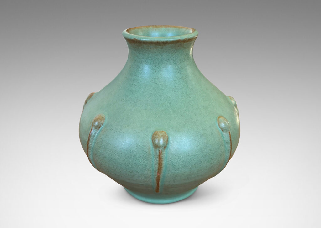 Gallery BAC bulbous form with outstretched mouth and relief organic motifs, in a celadon green glaze with brown accents