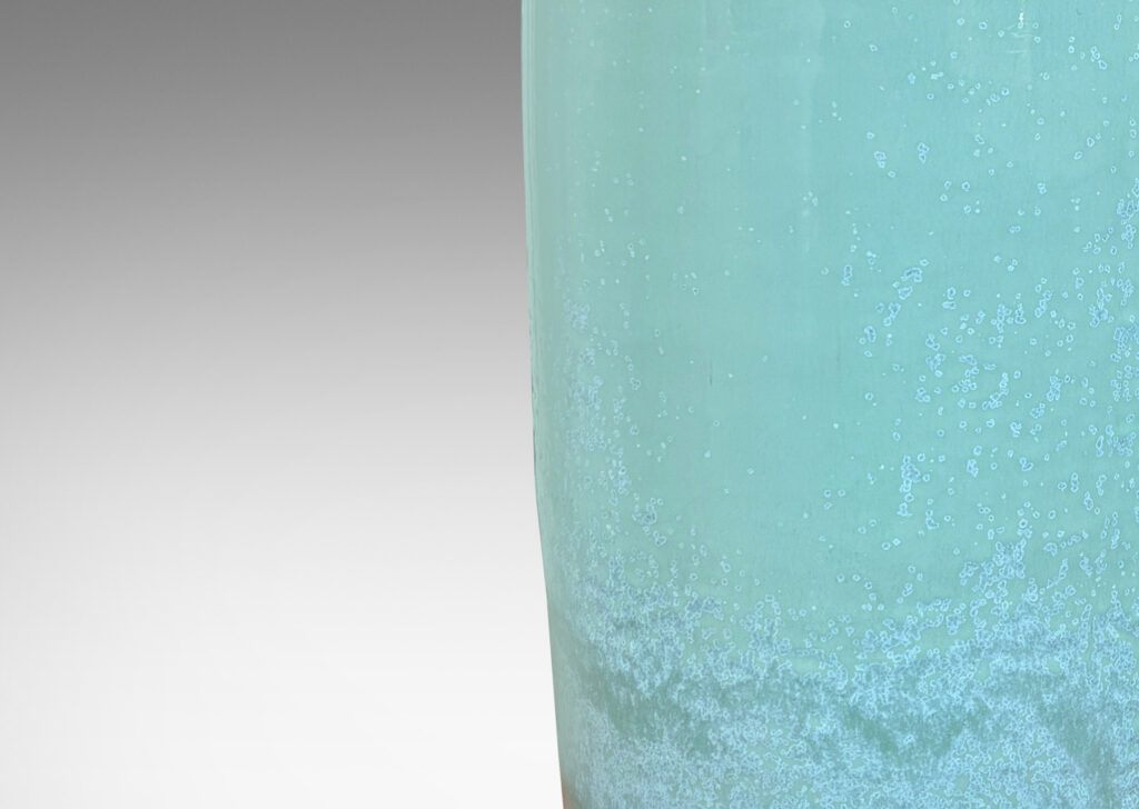 Gallery BAC tall tapered form glazed in a thick celadon tone with speckling and nice flow line at base