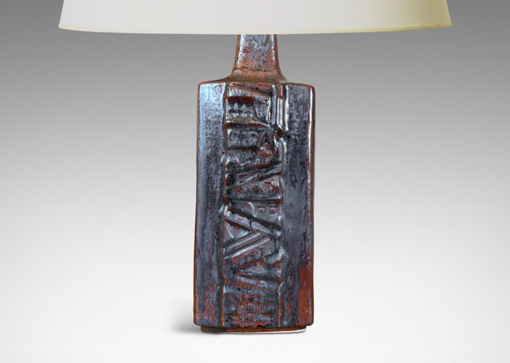 Gallery BAC rectangular bottle form with wide bands of geometric ornament in relief, glazed in an oxblood with gray glaze