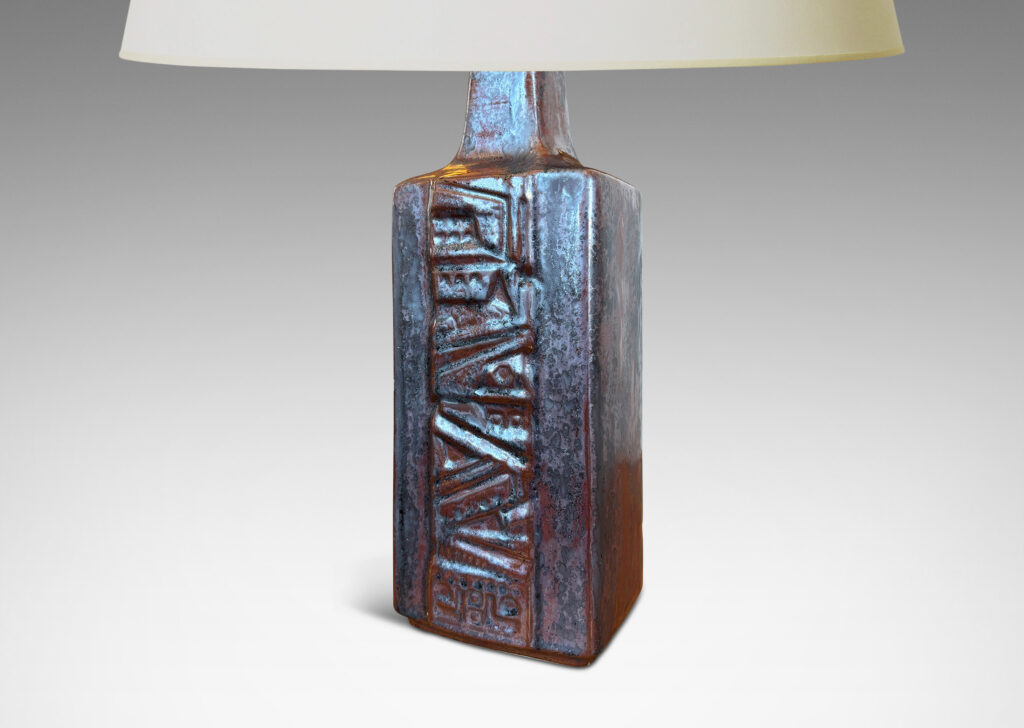 Gallery BAC rectangular bottle form with wide bands of geometric ornament in relief, glazed in an oxblood with gray glaze