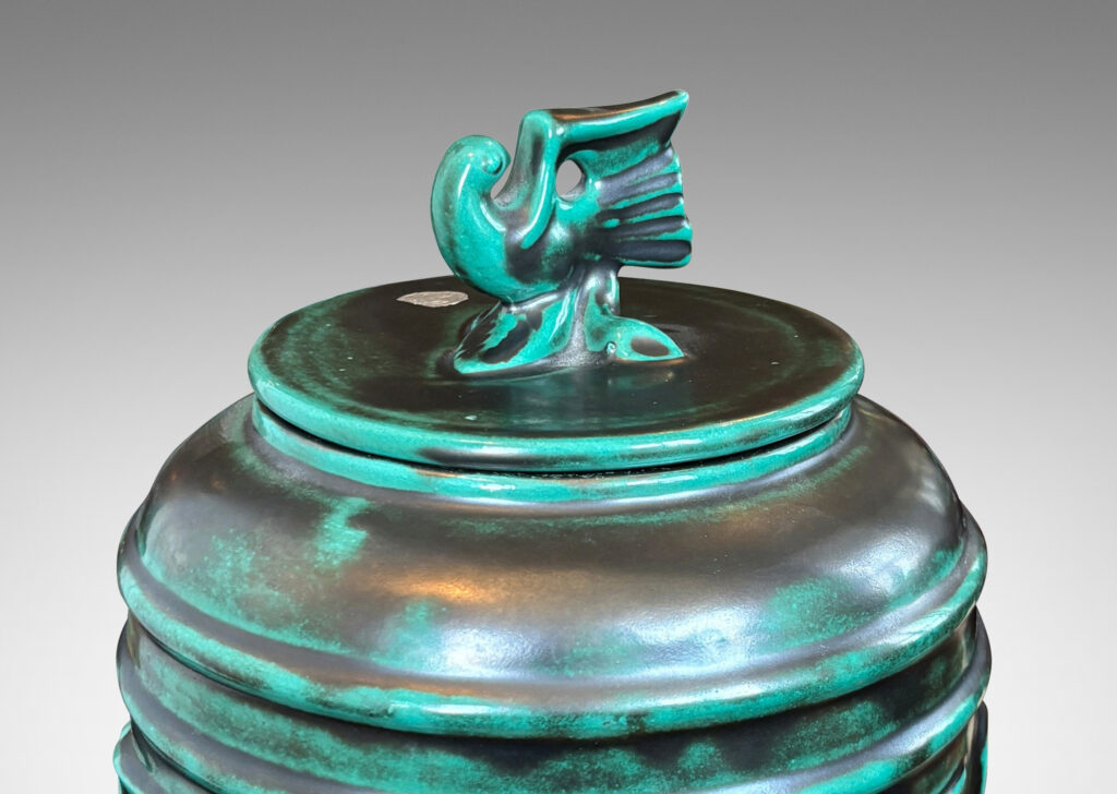 Gallery BAC wide relief band of abstract bird and foliate motifs, with lid topped with a bird finial, in deep tonal teal copper oxide glazing