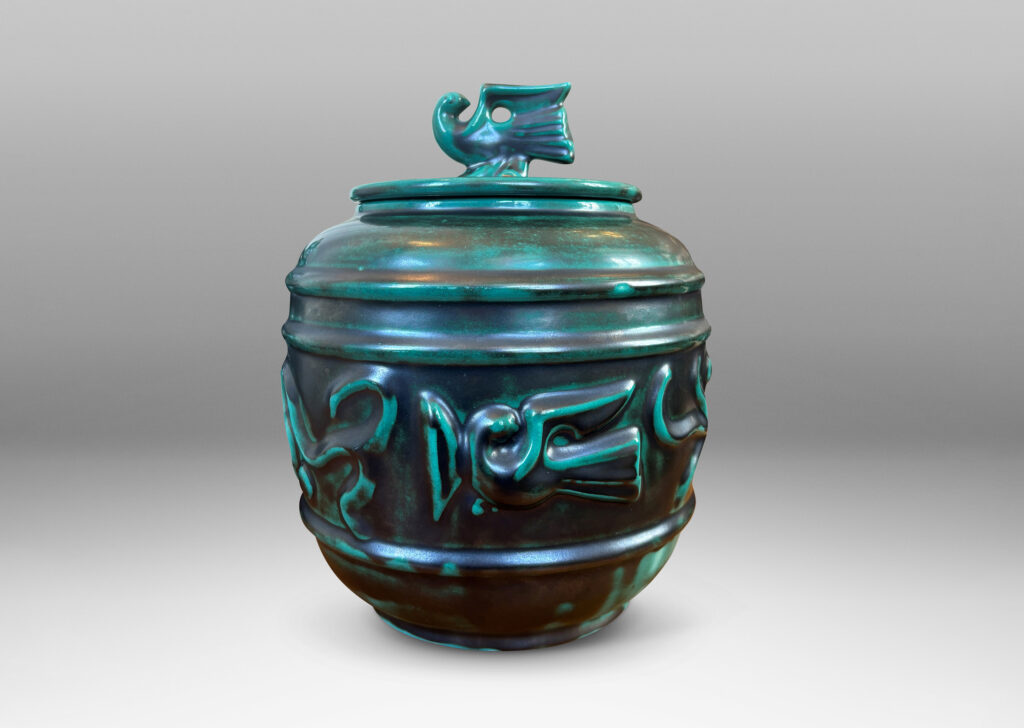 Gallery BAC wide relief band of abstract bird and foliate motifs, with lid topped with a bird finial, in deep tonal teal copper oxide glazing