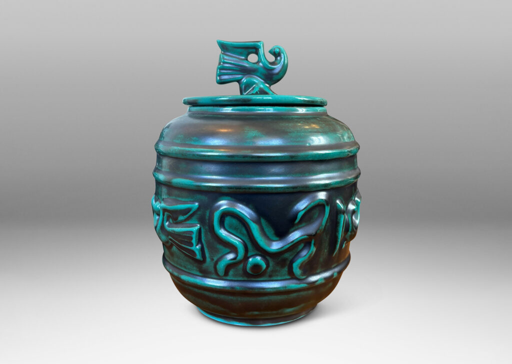 Gallery BAC wide relief band of abstract bird and foliate motifs, with lid topped with a bird finial, in deep tonal teal copper oxide glazing