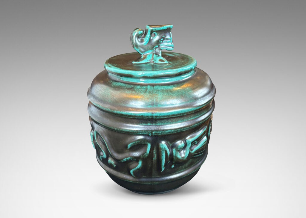 Gallery BAC wide relief band of abstract bird and foliate motifs, with lid topped with a bird finial, in deep tonal teal copper oxide glazing