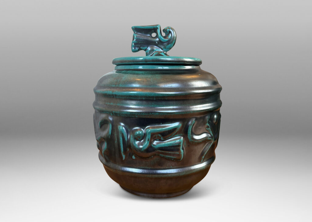 Gallery BAC wide relief band of abstract bird and foliate motifs, with lid topped with a bird finial, in deep tonal teal copper oxide glazing