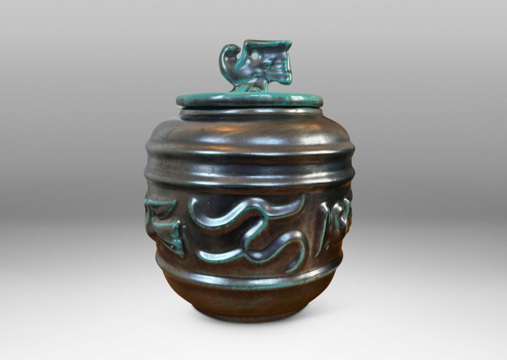 Gallery BAC wide relief band of abstract bird and foliate motifs, with lid topped with a bird finial, in deep tonal teal copper oxide glazing