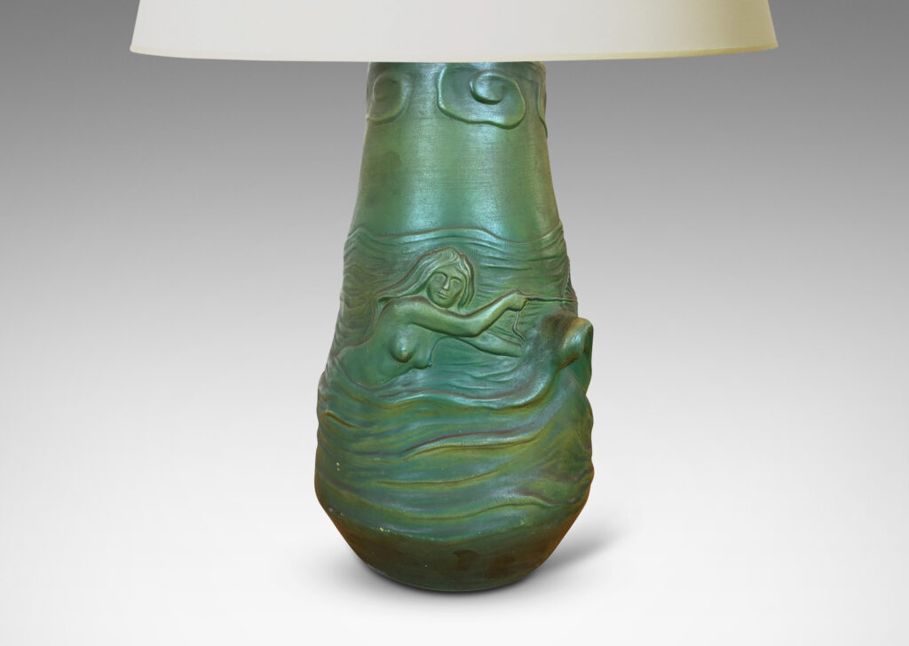 Gallery BAC bell-like form encircled in reliefs depicting waves, fish, mermaids and cloud ball motifs, glazed in a matte dark green