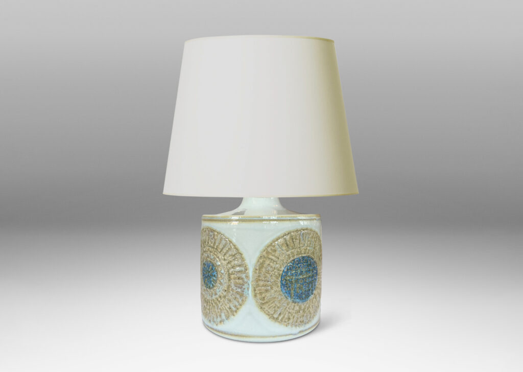 Gallery BAC drum form with relief abstracted floral motifs, glazed in olive-tan and turquoise against a pale gray background