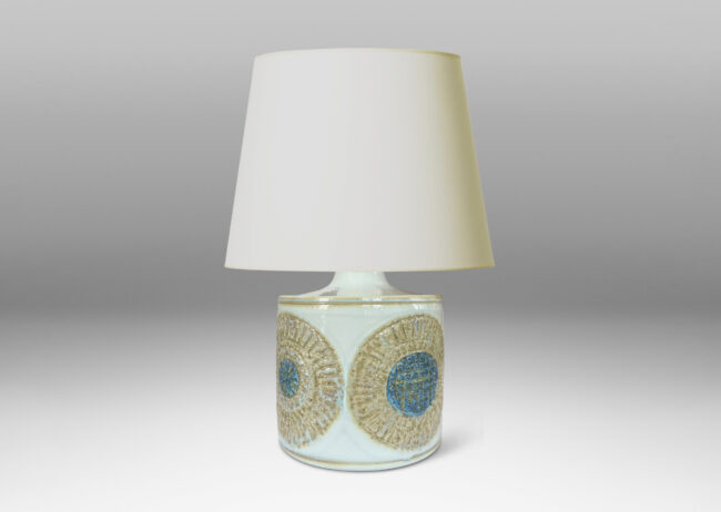 Gallery BAC drum form with relief abstracted floral motifs, glazed in olive-tan and turquoise against a pale gray background