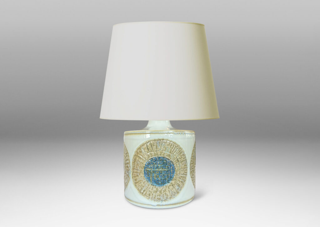 Gallery BAC drum form with relief abstracted floral motifs, glazed in olive-tan and turquoise against a pale gray background