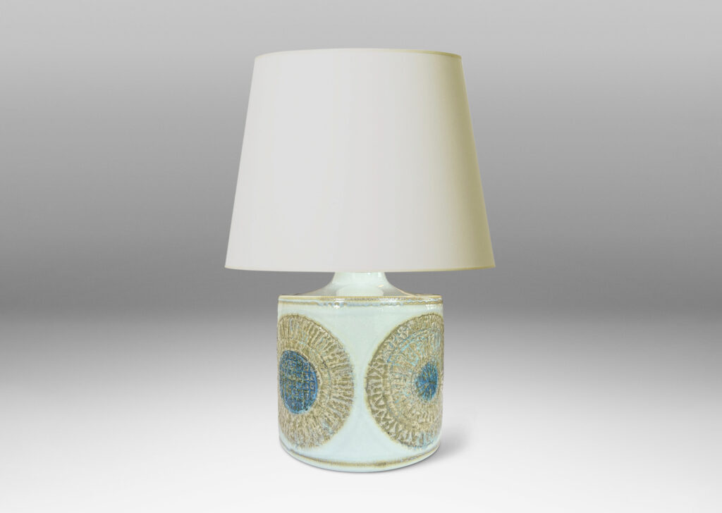 Gallery BAC drum form with relief abstracted floral motifs, glazed in olive-tan and turquoise against a pale gray background