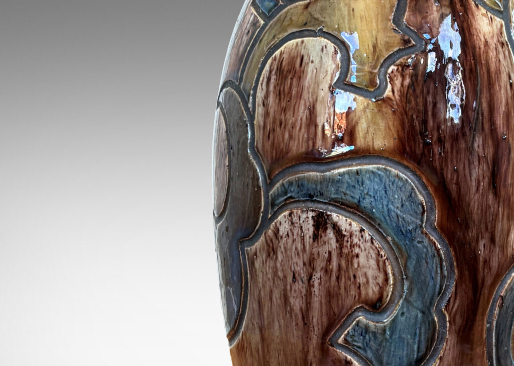 Gallery BAC carved design of scalloped forms, glazed in dark brown, blue and light raw umber