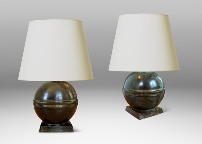 Gallery BAC globe forms with engraved bands, mounted on an angled square plinth, having a handsome original patination; bronze