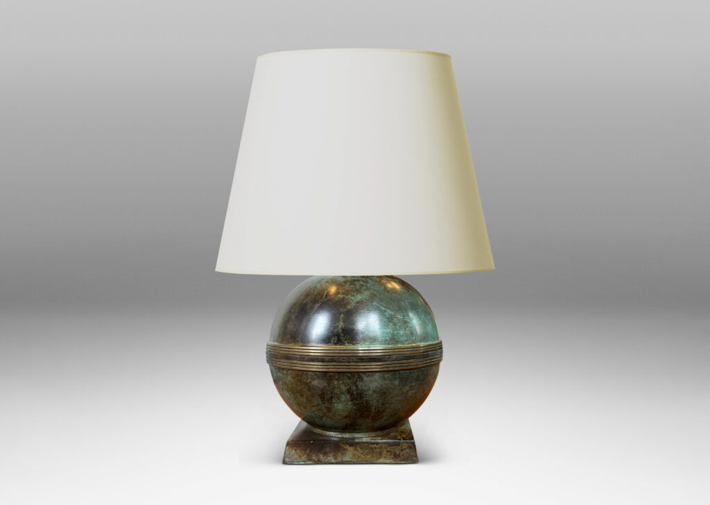 Gallery BAC globe forms with engraved bands, mounted on an angled square plinth, having a handsome original patination; bronze