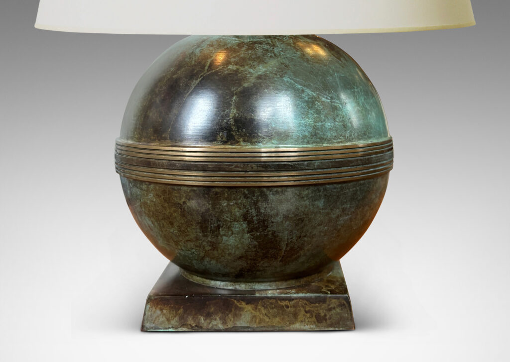 Gallery BAC globe forms with engraved bands, mounted on an angled square plinth, having a handsome original patination; bronze