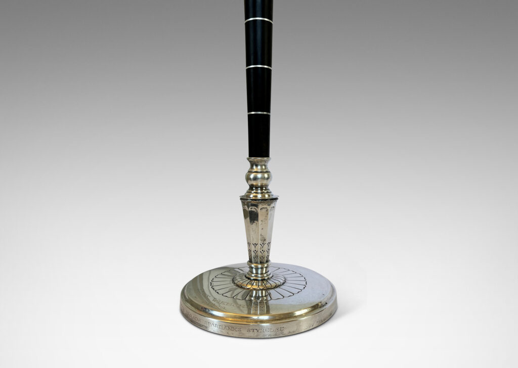 Gallery BAC tapered stand in ebony with pelmeted cap and rosette ornamented base; silver and wood