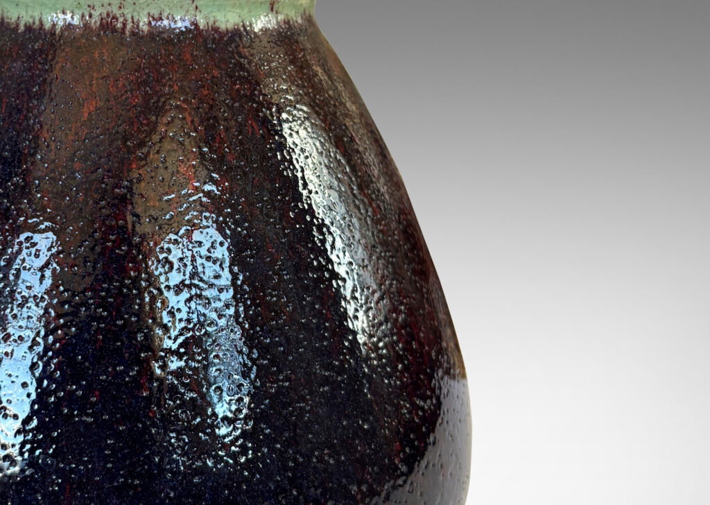 Gallery BAC organically modeled bulbous form with wide mouth, glazed in a shiny oxblood with pale gray accents