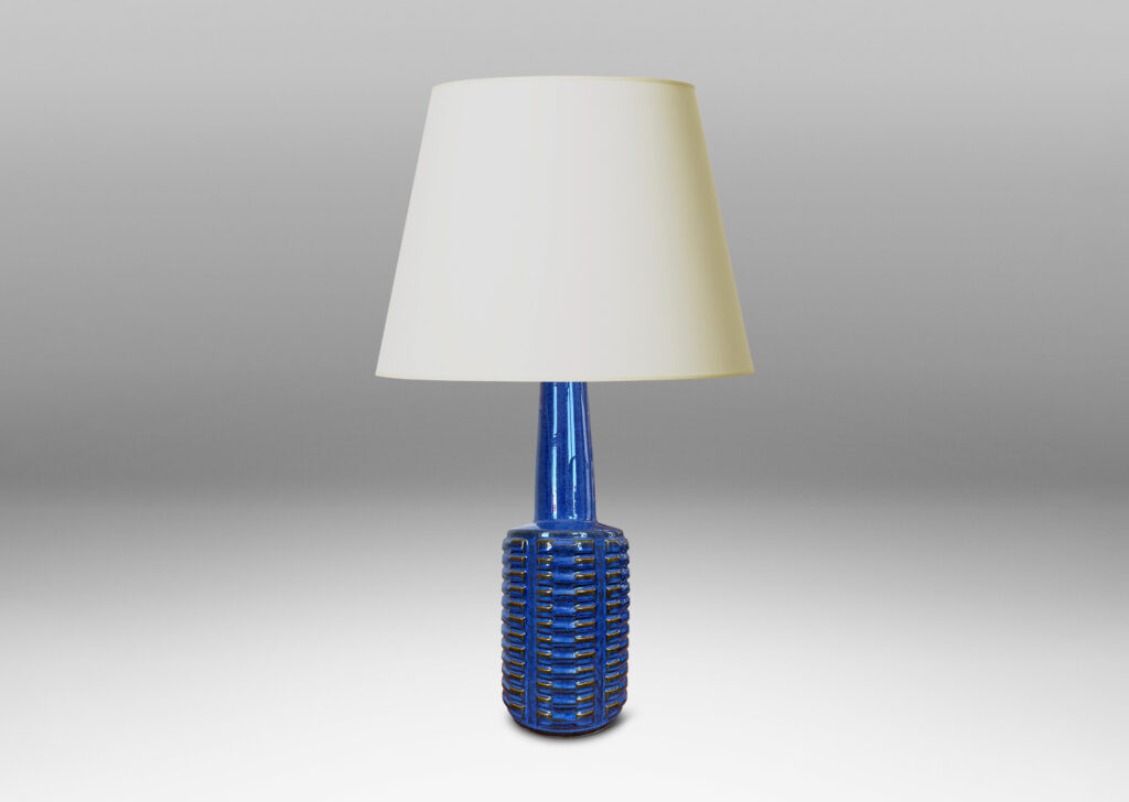 Gallery BAC cylindrical form with stacks of impressed motifs in relief and a tapered neck, glazed in a saturated blue-brown