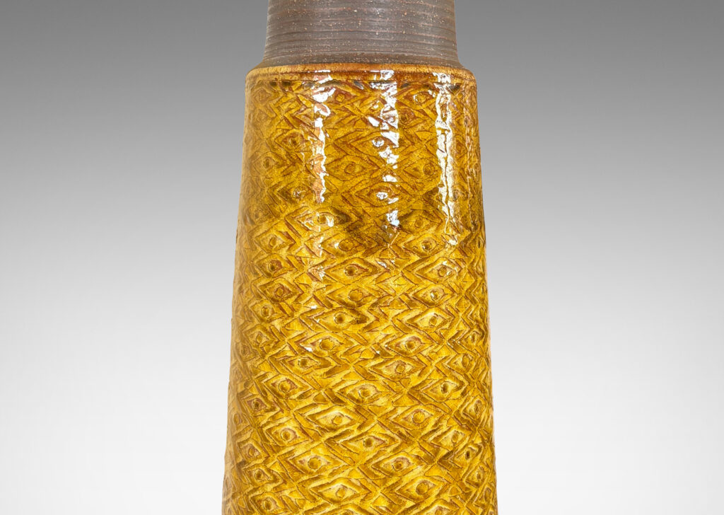 Gallery BAC tall conical form ornamented with a zig-zag / lozenge pattern, glazed in a shiny deep golden honey tone with matte brown ring