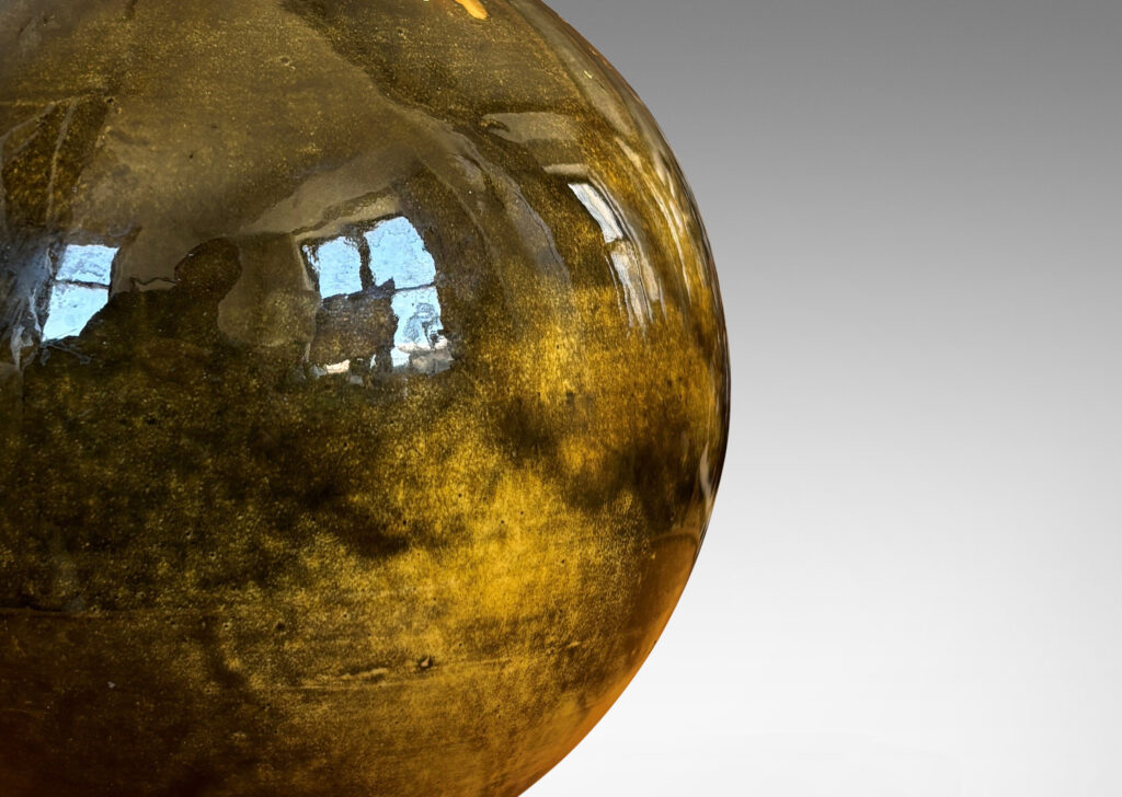 Gallery BAC rationalized baluster form, with spherical body, disk base and flared neck, glazed in yellow-black; earthenware