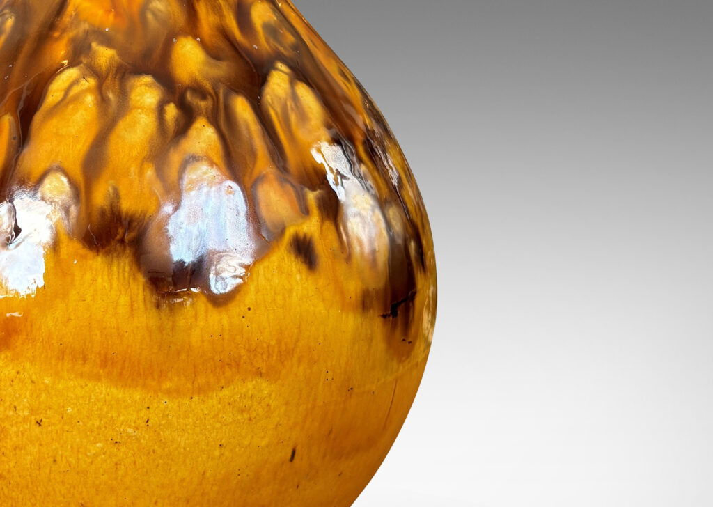 Gallery BAC angled gourd-like form glazed in a golden yellow with flowing brown accents