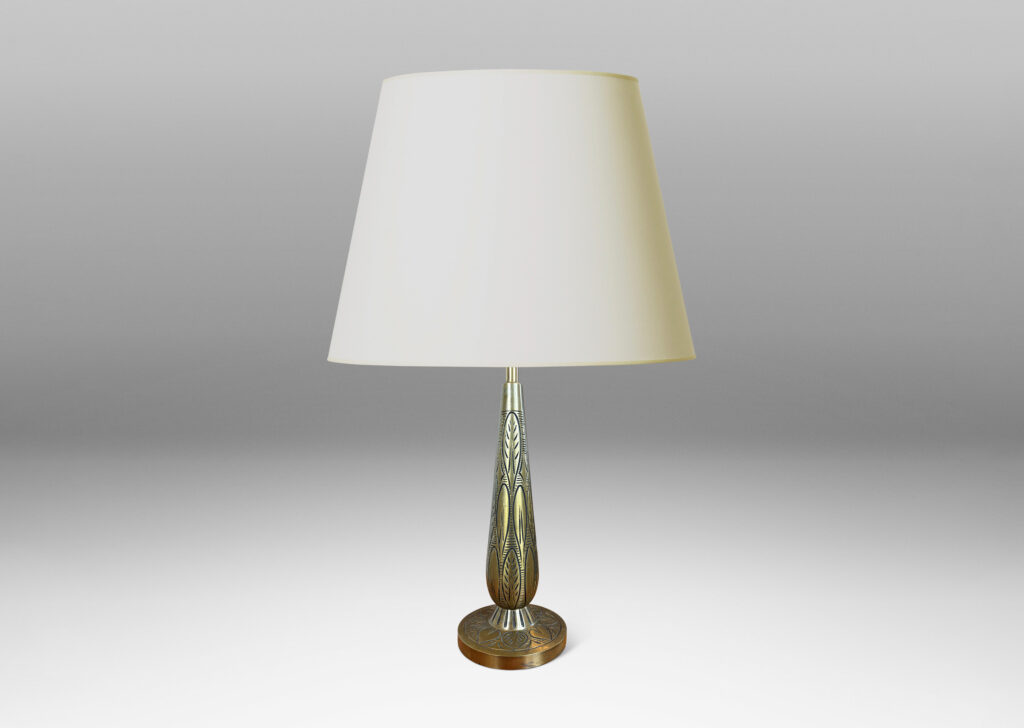 Gallery BAC elongated drop form on a disk plinth, ornamented with carved foliate pattern; patinated brass